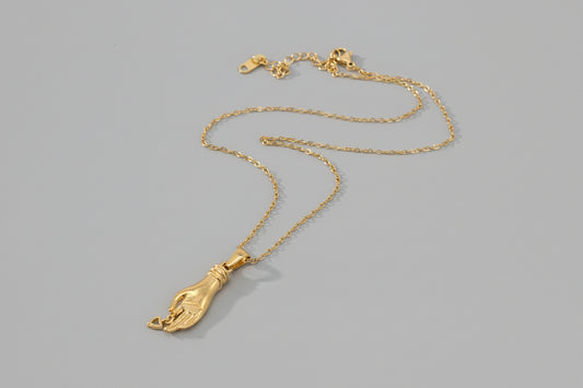 Gold necklace with a pendant on a white background
