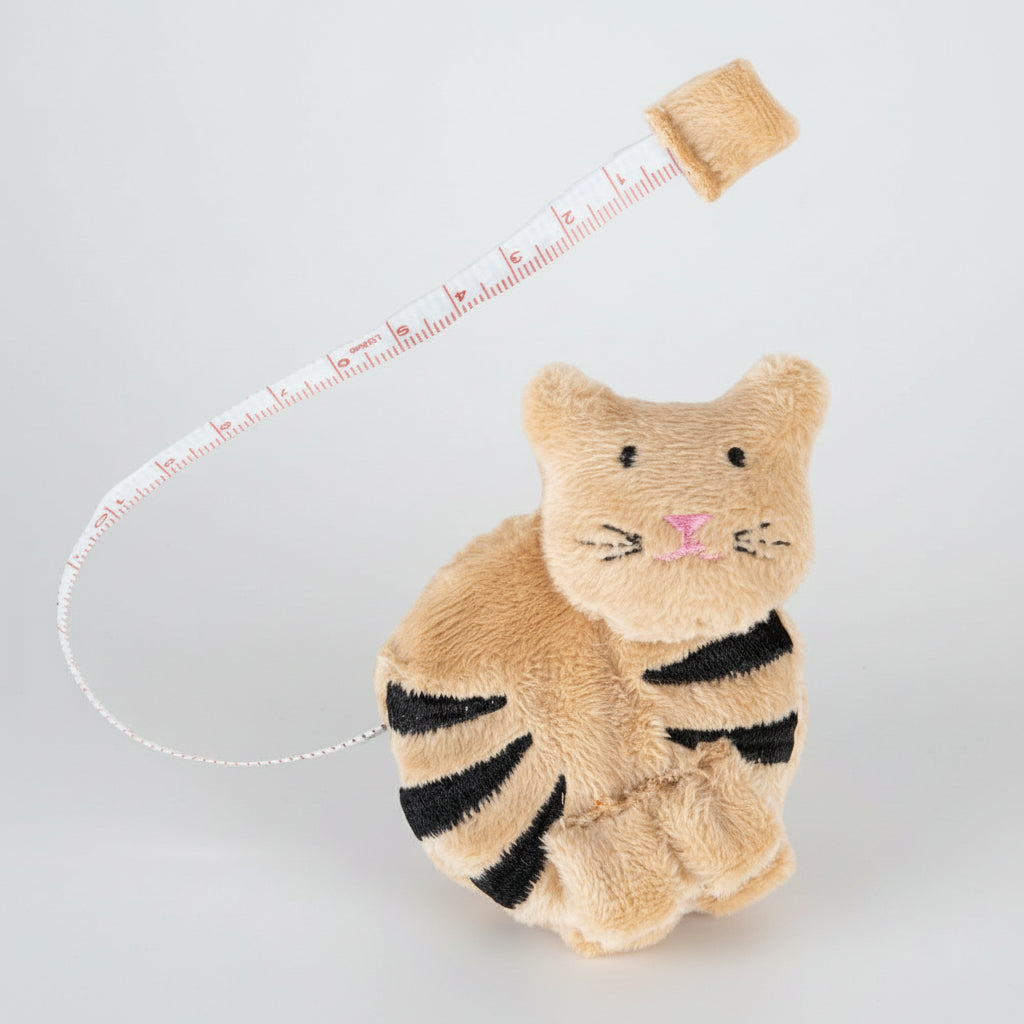 A beige fabric cat tape measurer on a white background