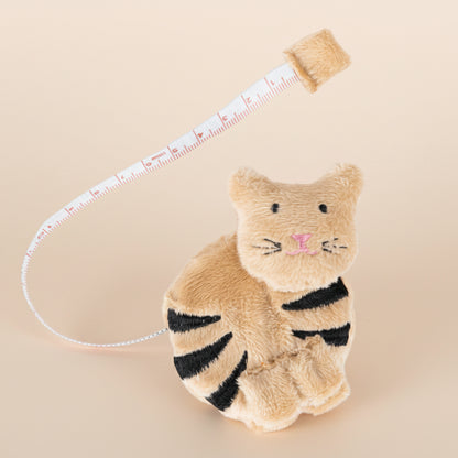 A beige fabric cat tape measurer on a white background