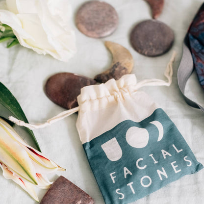 Facial stones with a drawstring bag labeled 'Facial Stones' on a light background.