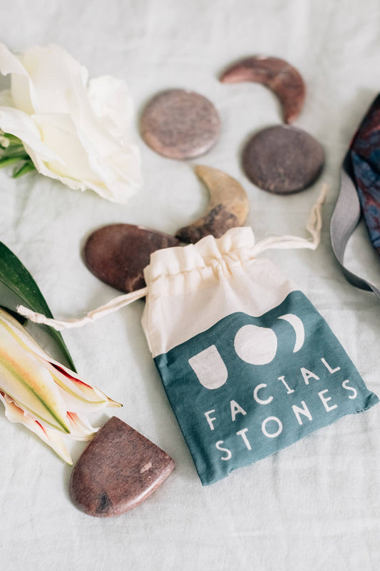 Facial stones with a drawstring bag labeled 'Facial Stones' on a light background.