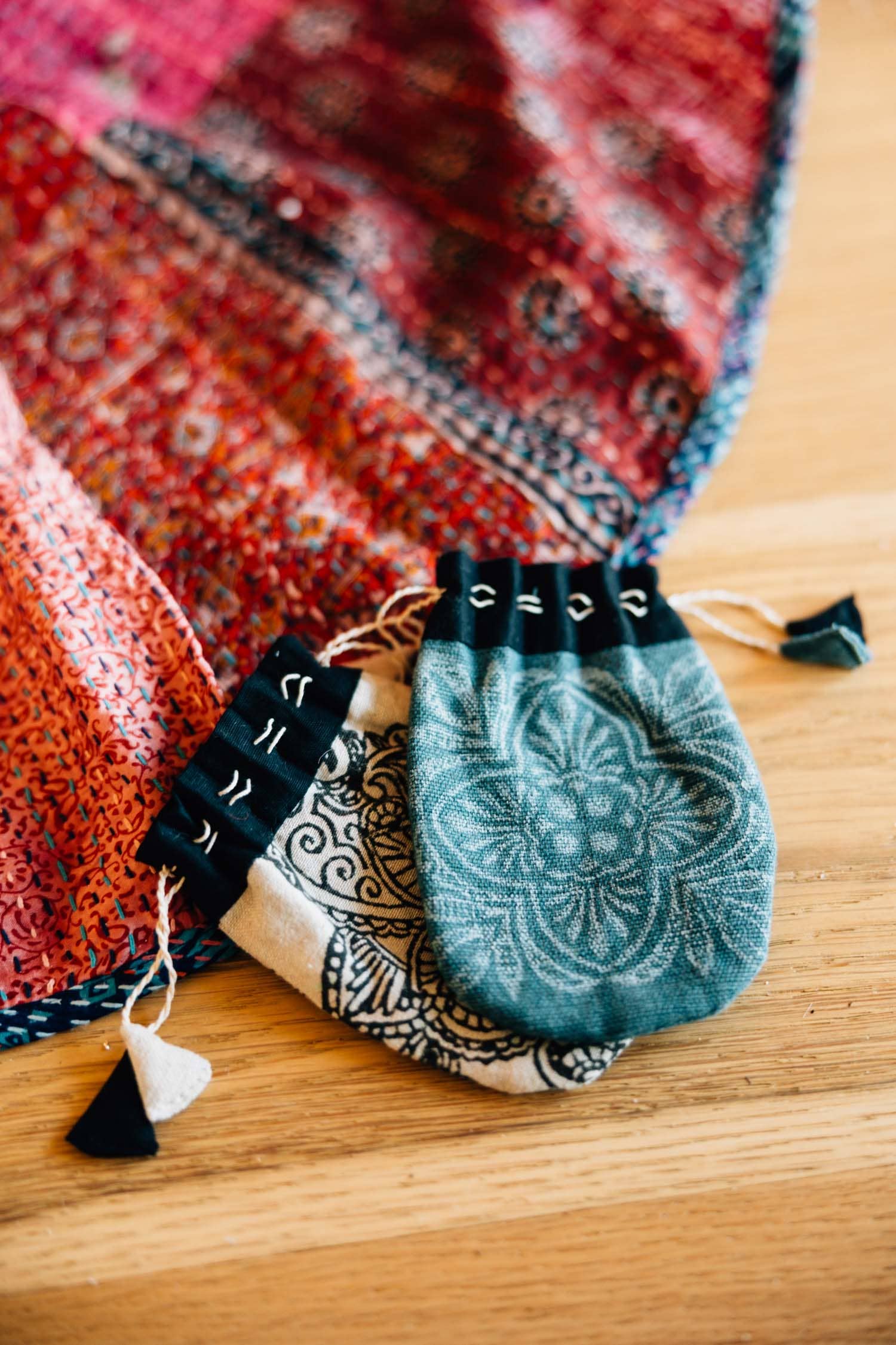 Close up of assorted drawstring gift bags next to a fiber art piece 