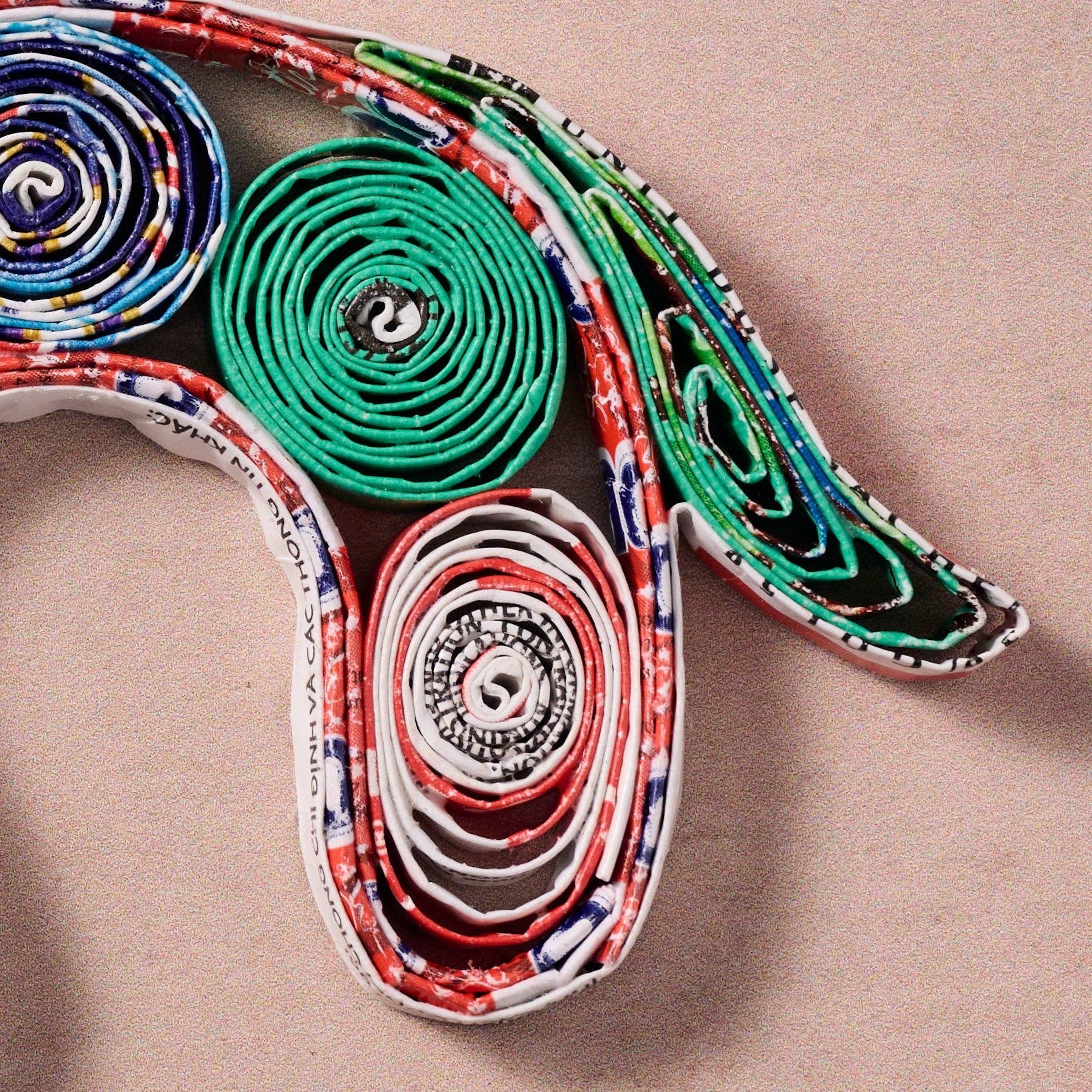 Colorful paper roll sculpture on a beige background