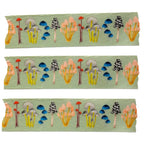 Three strips of fabric with colorful forest pattern on a green background