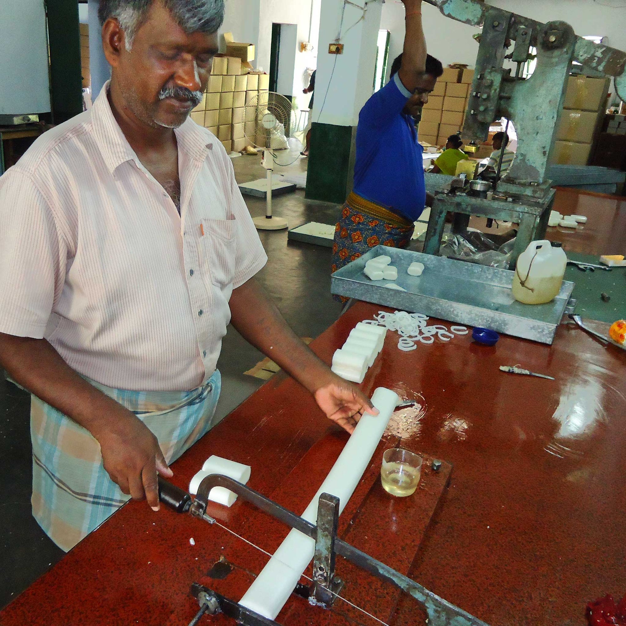 Man working with a tool on a table in an industrial setting