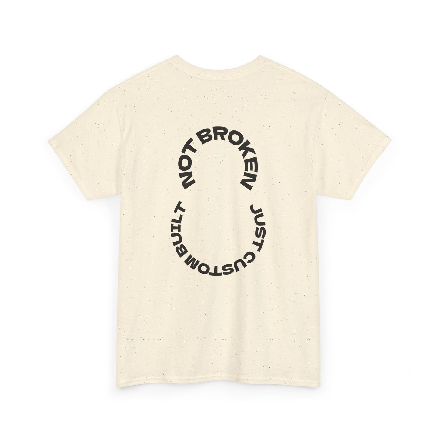 Beige t-shirt with black circular text that says, "Not Broken, Just Custom Built" design on a white background