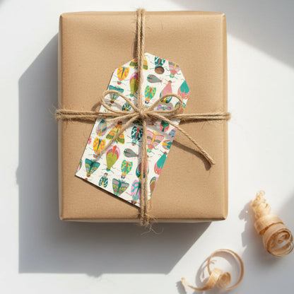 Dancing Bug gift tag on a brown paper wrapped gift and twine on a white background
