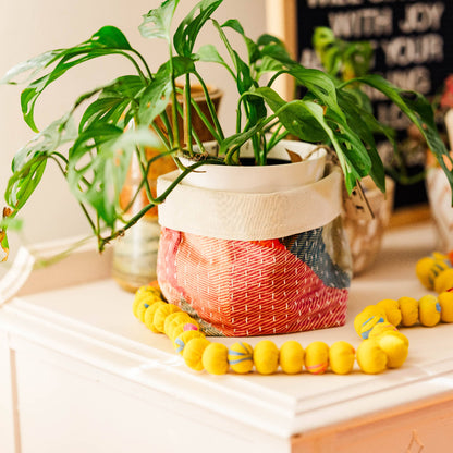Decorative items including a plant, colorful beads, and a woven basket on a surface.