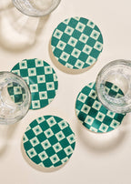 Close up of Green Checkered Star Coasters with glassware.