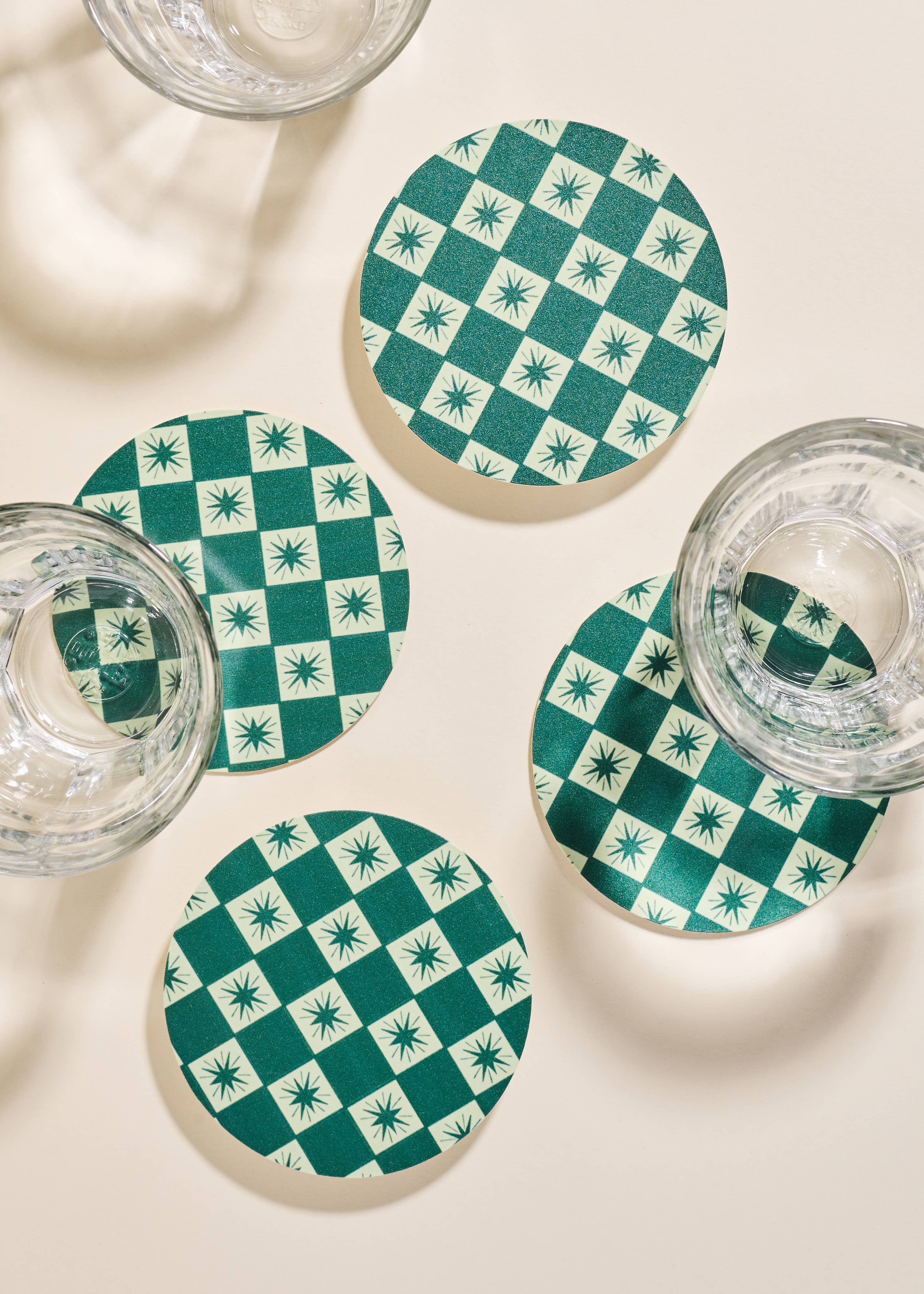Close up of Green Checkered Star Coasters with glassware.