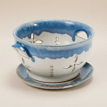 Ceramic colander with blue and white design on a white background