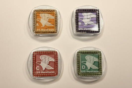 Four vintage-style postage stamps pressed with clear wax and detailed with multi-color gilding wax to accent the various colors.