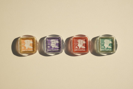 Four vintage postage stamp magnets created by Rochambeau Home on a white background.