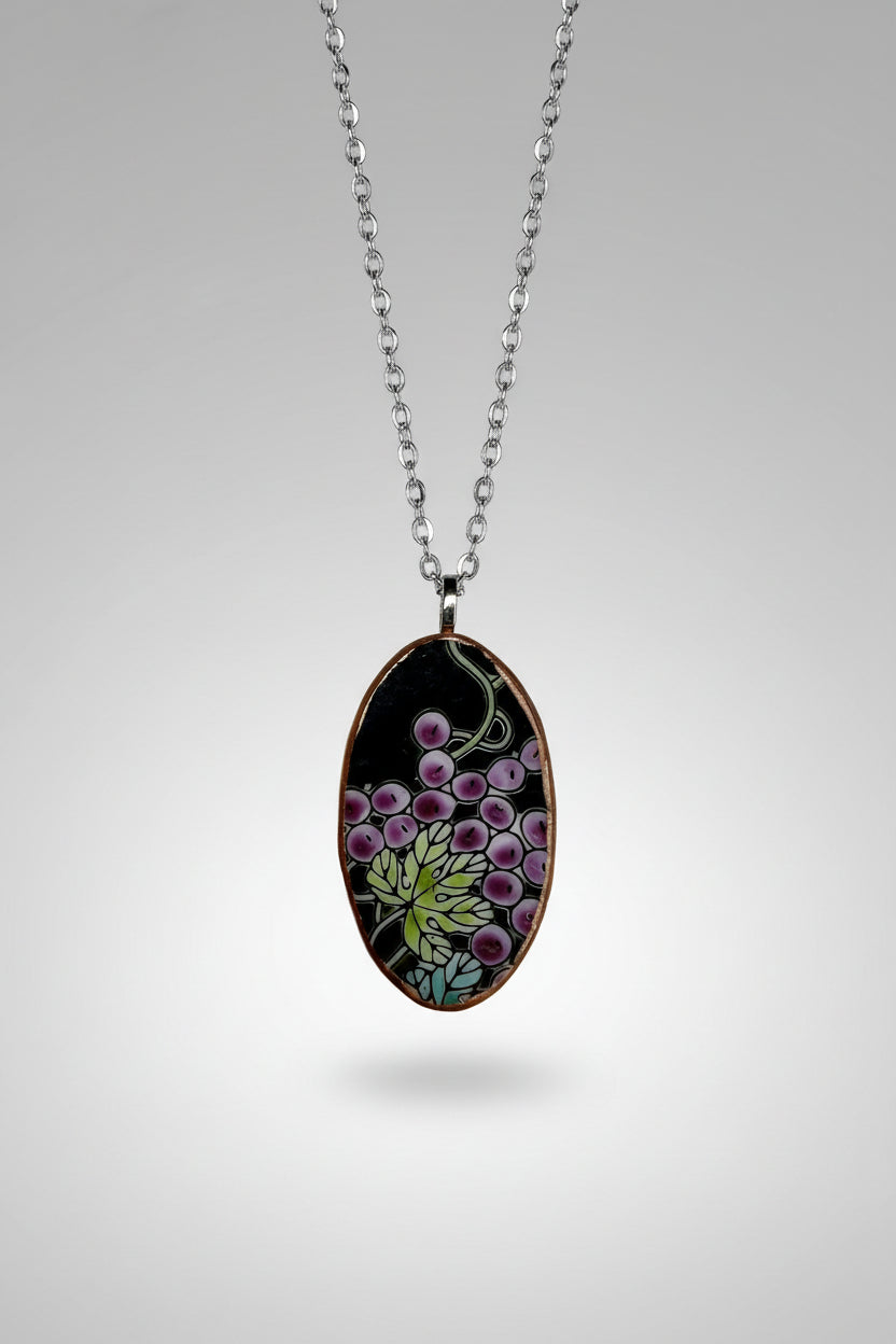 Necklace with an oval pendant featuring black and purple floral design on a white background