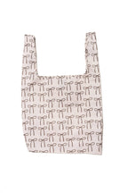 A cream-colored foldable tote adorned with brown bows, made from high-quality ripstop nylon for durable everyday use.