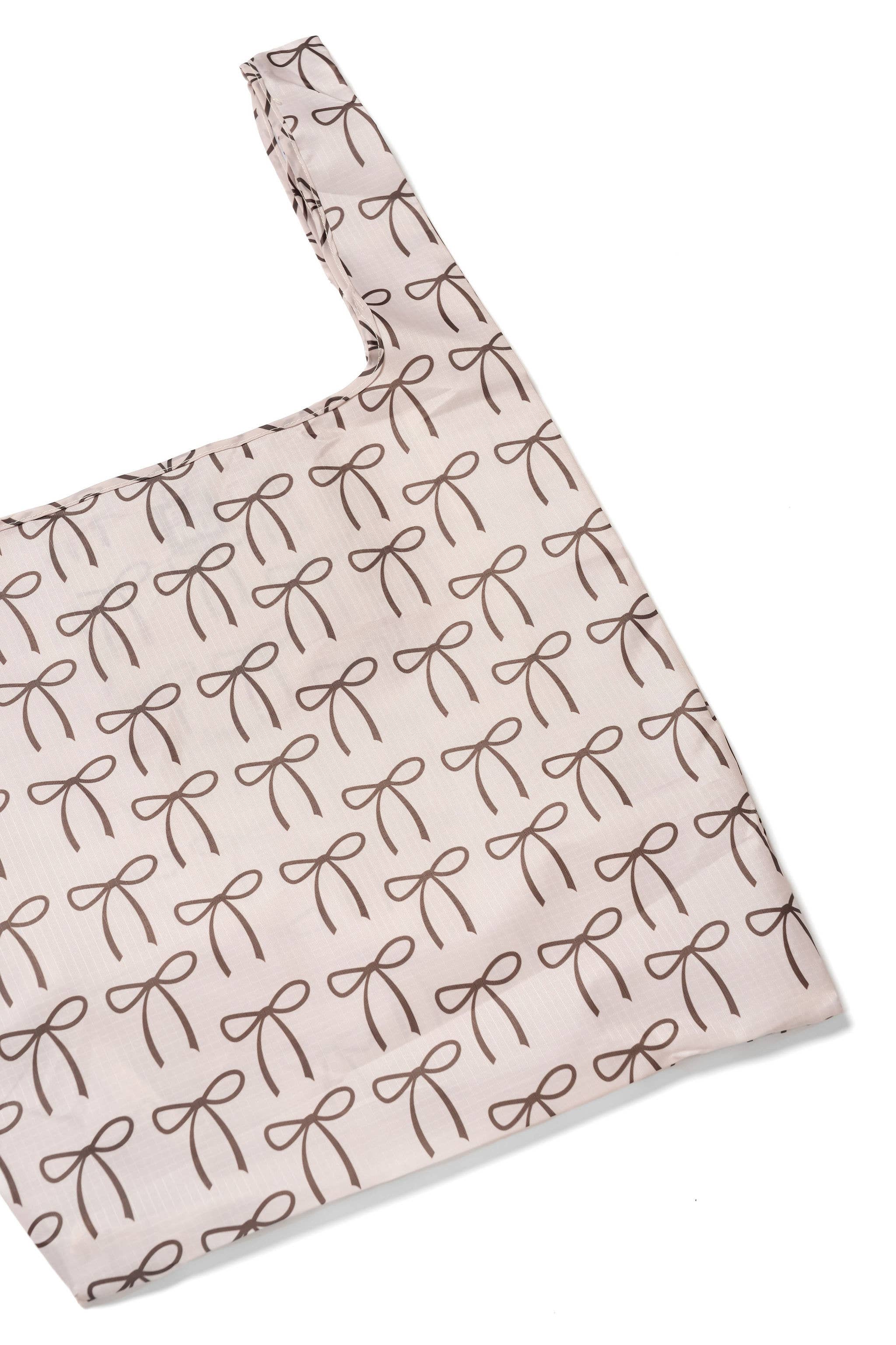 Close up of the Elise Bag from BRNG Bag with brown bows on a neutral background.