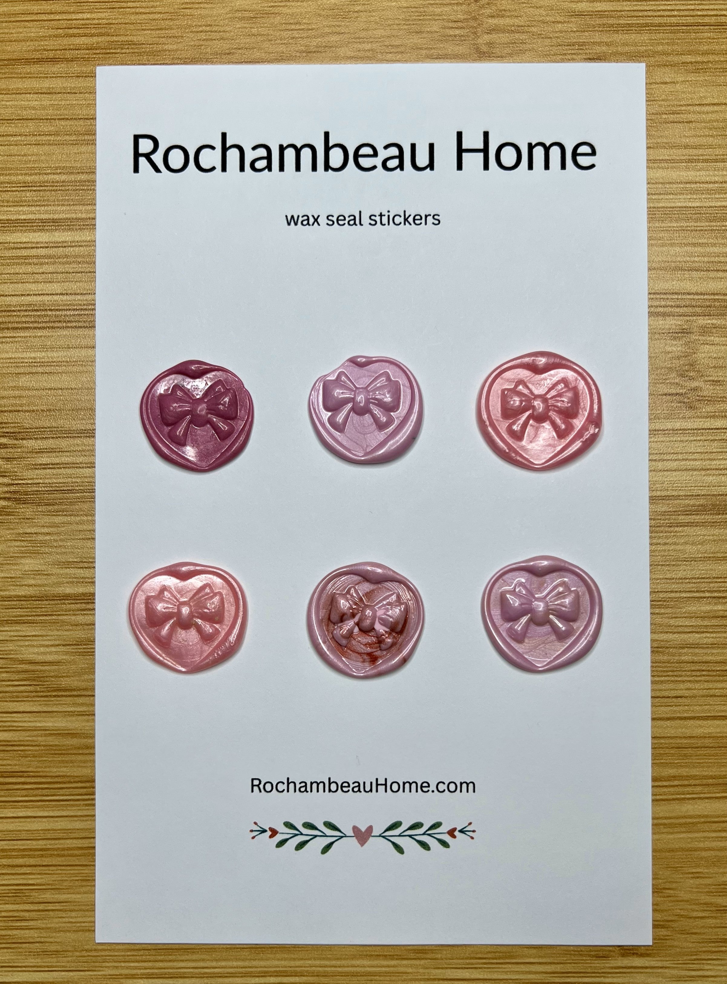 Close up view of the Heart & Bow wax seal stickers in a pink hue