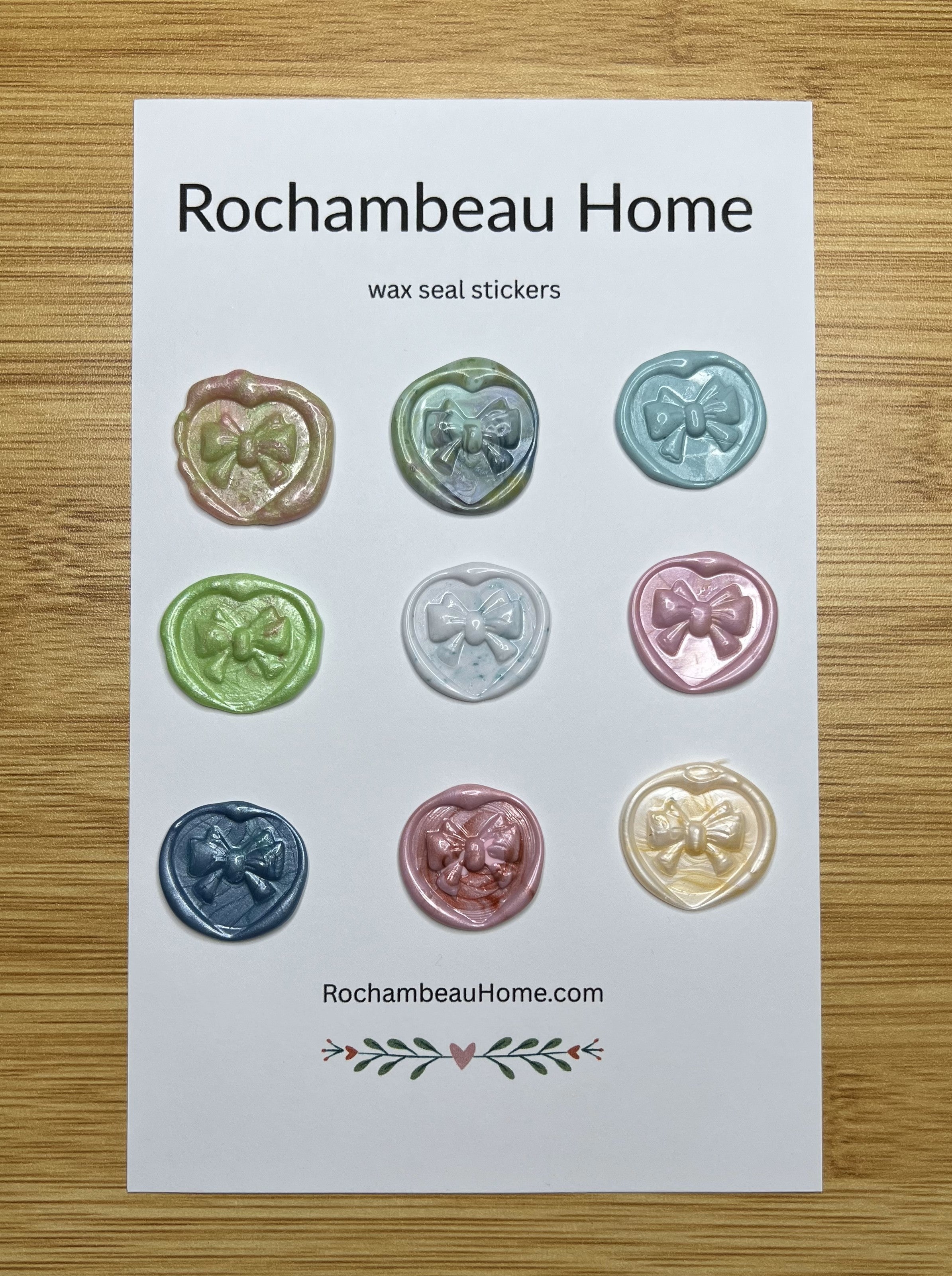 Close up view of the Heart & Bow wax seal stickers in a variety of colors on a 9 pack card