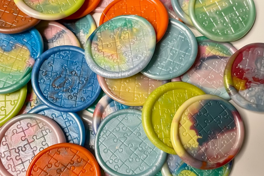 Collection of Autism Awareness wax seal stickers embossed with puzzle pieces in various pastel colors, created by Rochambeau Home.