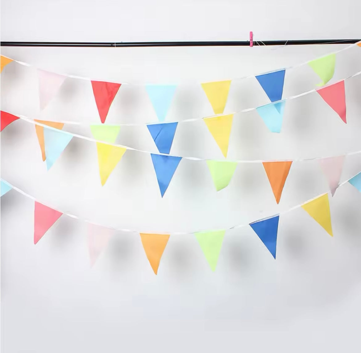 Long colorful fabric banner strung across an outdoor birthday setup