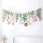 Whimsical floral garland hanging across a party table setup
