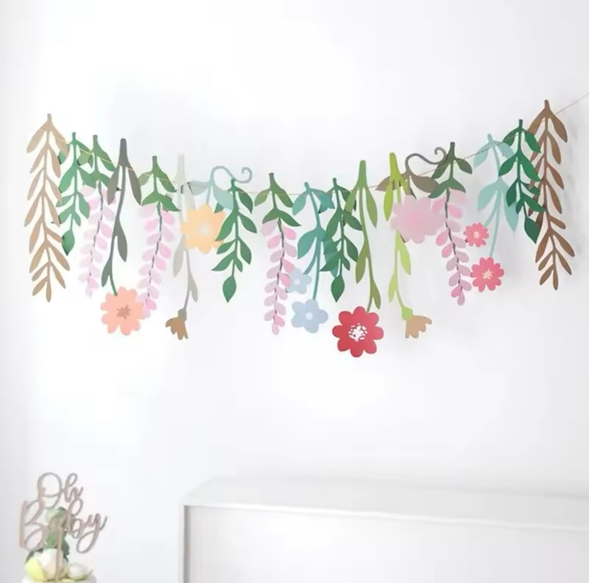 Whimsical floral garland hanging across a party table setup