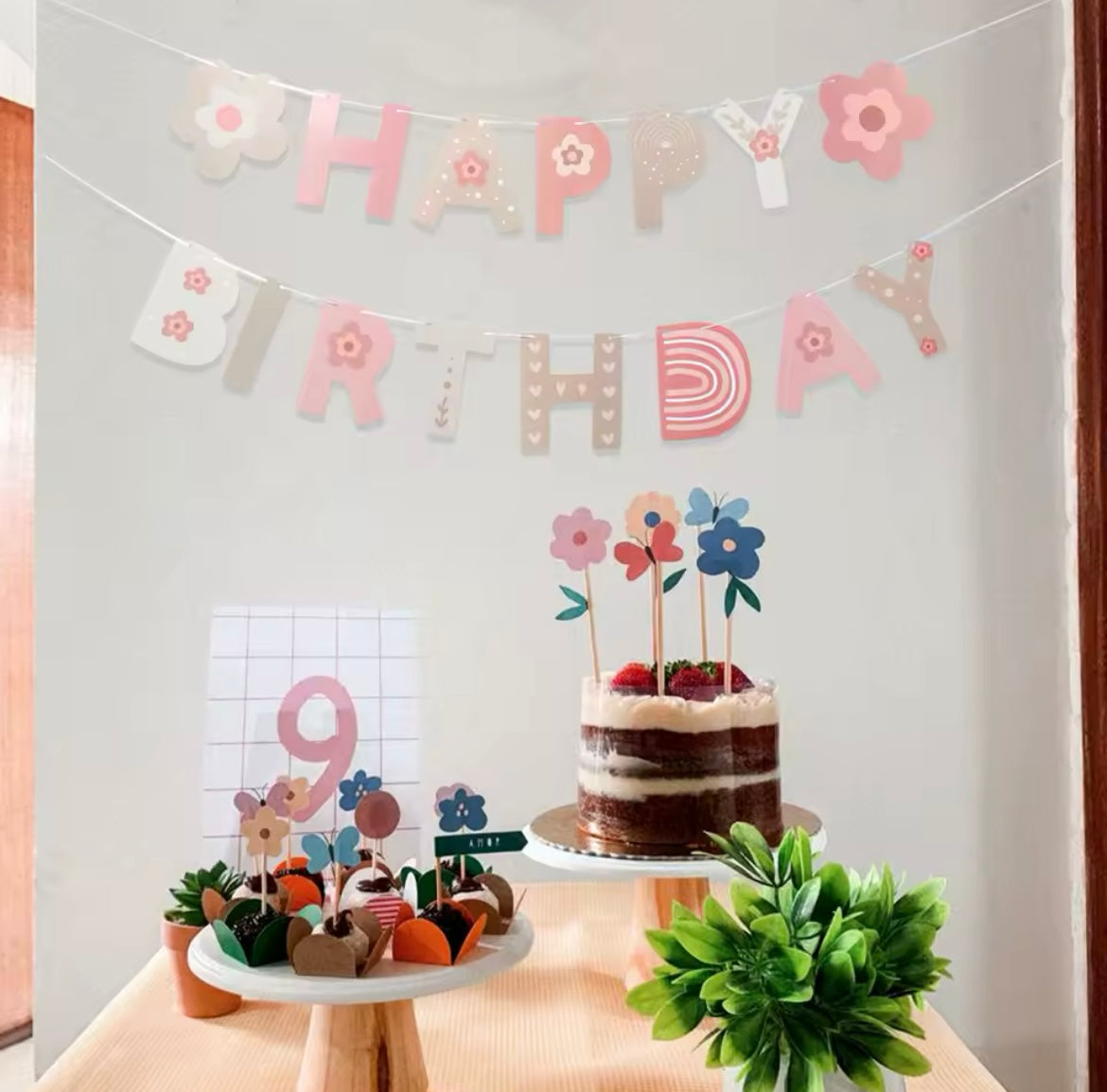 Banner styled at a little girl’s birthday party with pastel decorations