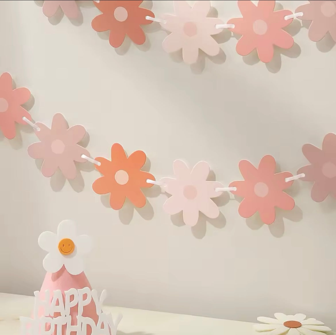 Close-up of layered paper daisy flags in vintage shades of pink