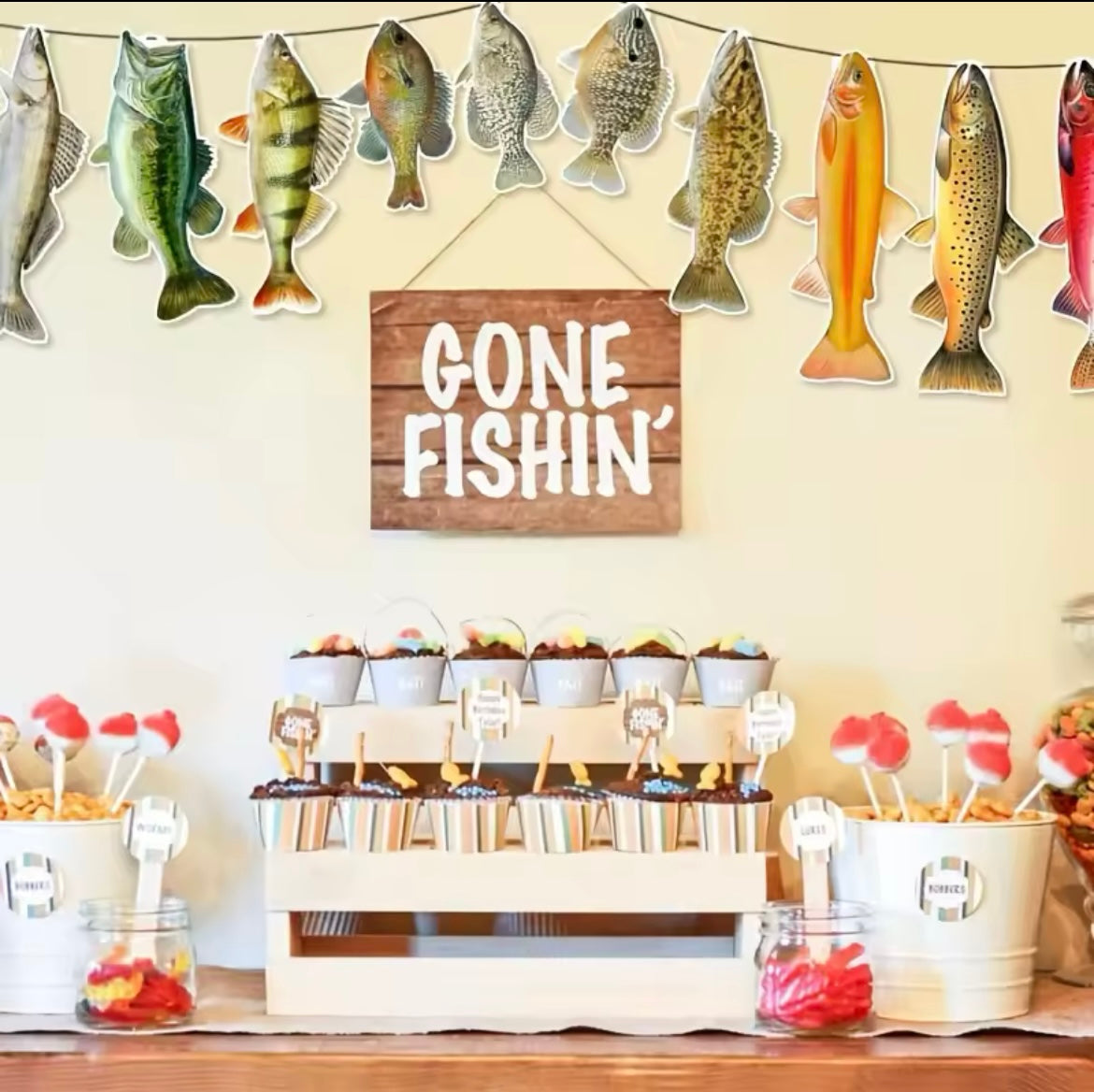 Banner hanging above a party table with fishing-themed decor