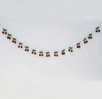 Red cherry felt banner hanging across a white wall for a summer party