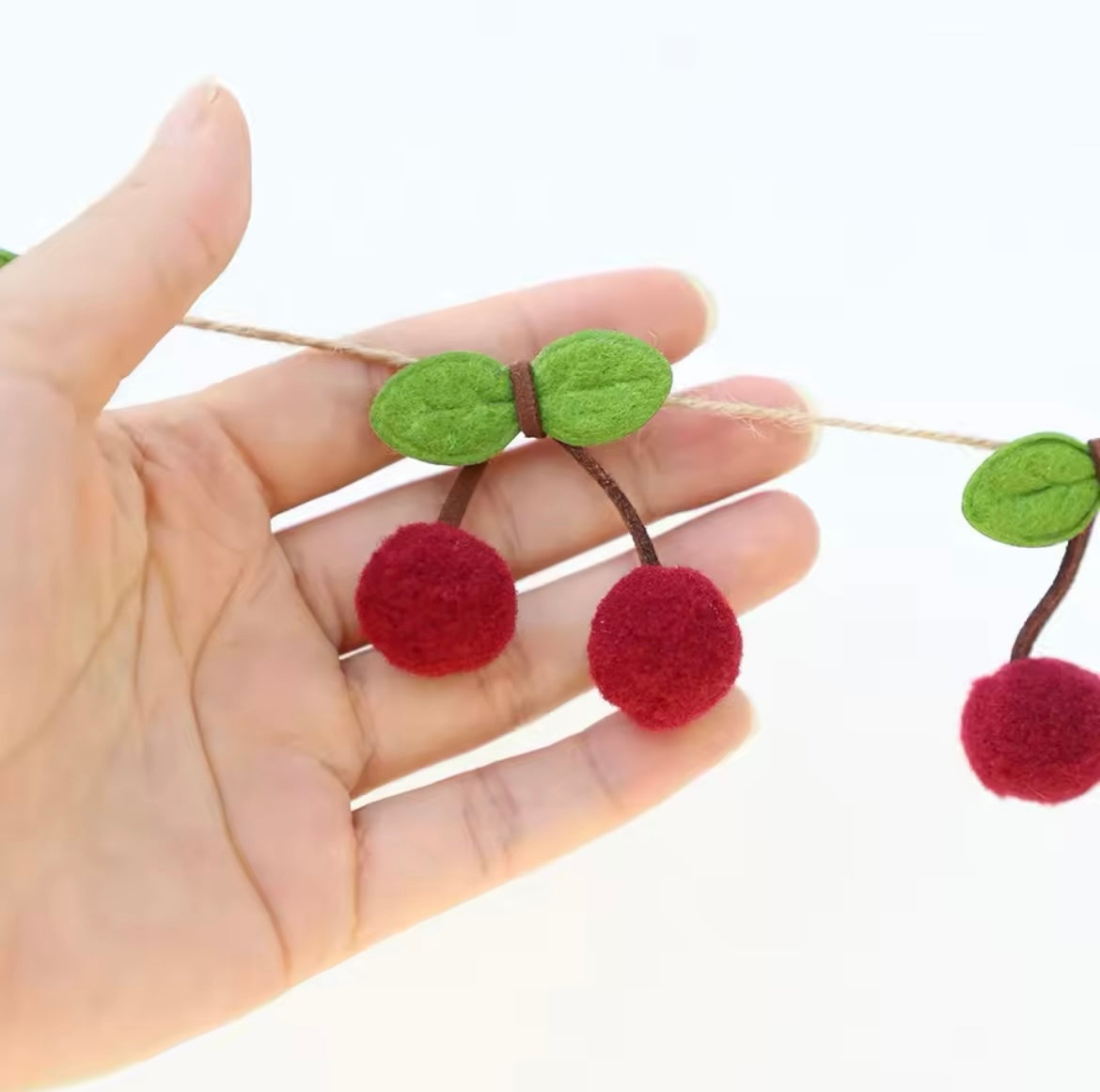 Close-up of felt cherry details on rustic kraft string
