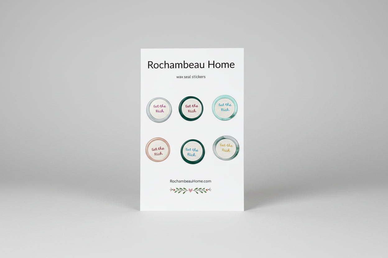 Close up view of the Eat the Rich wax seal stickers created by Rochambeau Home on a 6 pack card