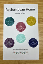 Close up view of the Lunar Moth boho wax seal stickers in a variety of colors on a paper card