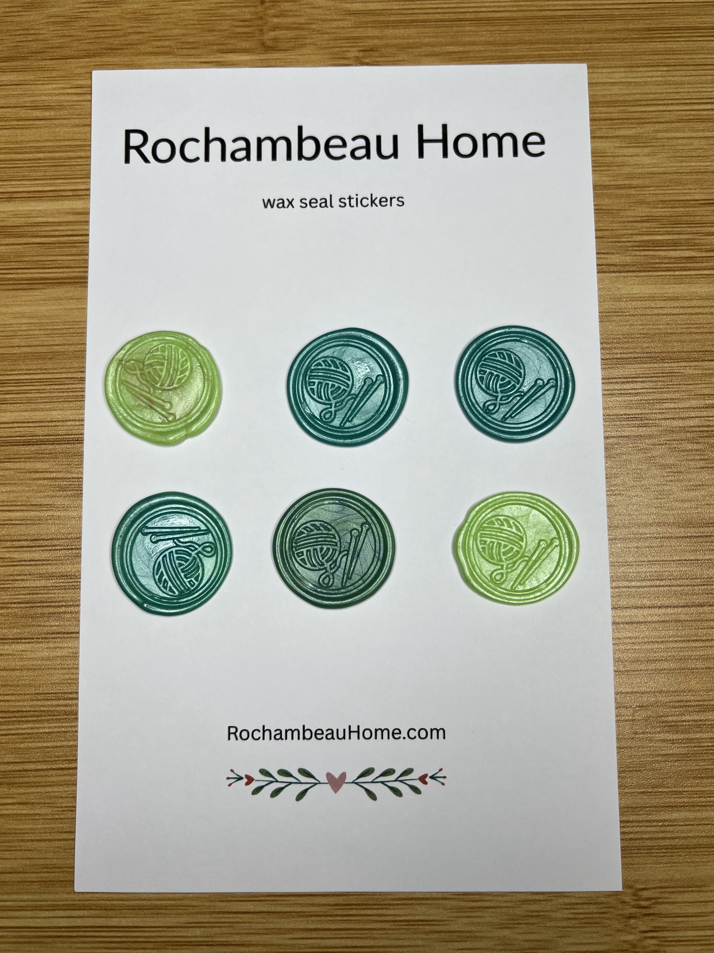 Close up view of the Handcrafted Knitting Circle wax seal stickers in a green hue