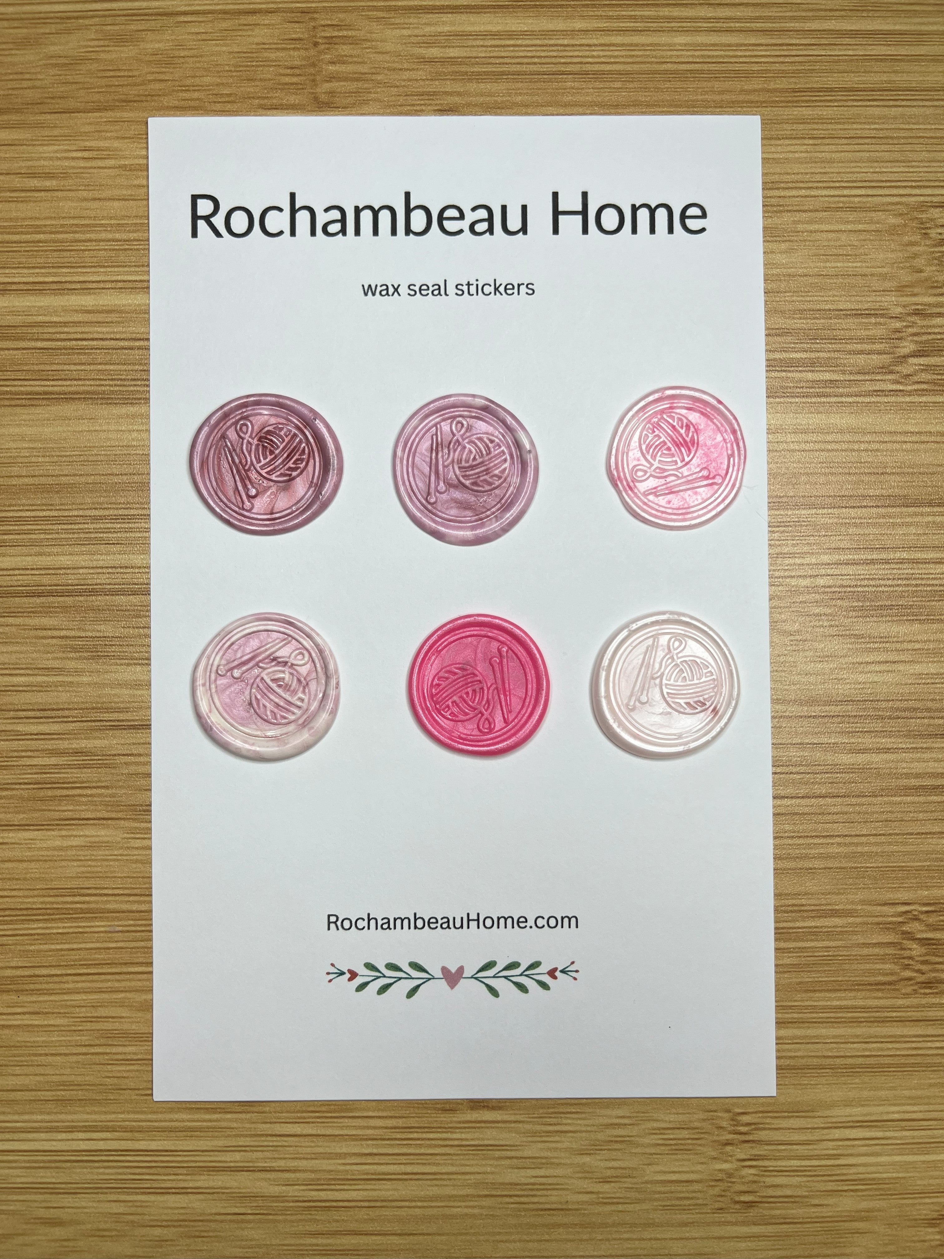 Close up view of the Handcrafted Knitting Circle wax seal stickers in a pink hue