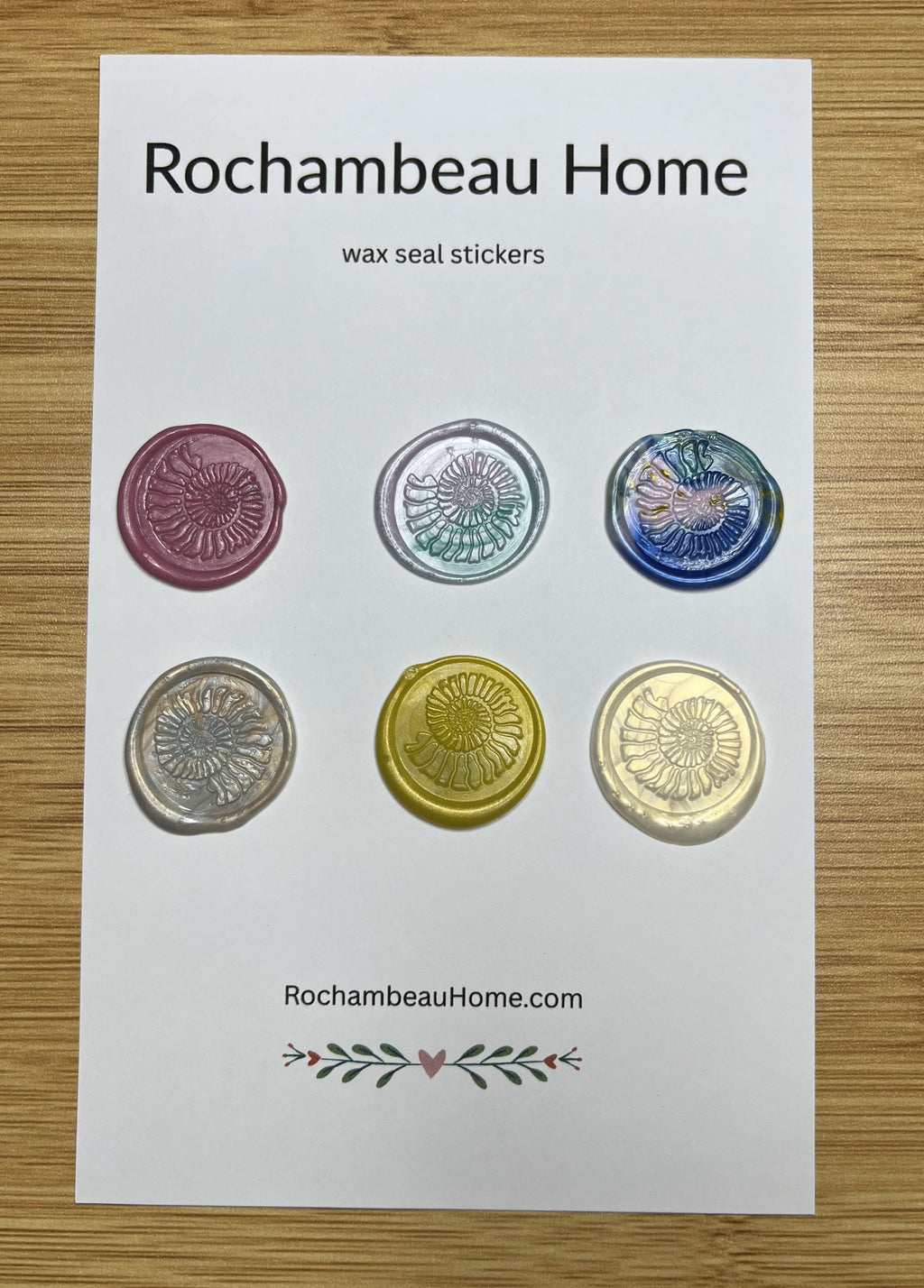 Close up view of the Spirals of Nature Ammonite wax seal stickers in a variety of colors on a 6 pack card