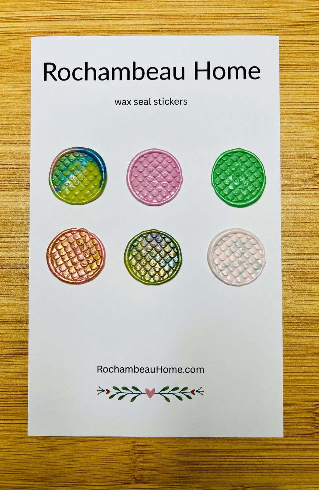 Close up view if the Hiss & Tell wax seal stickers on a 6 pack card