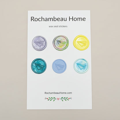Multicolor wax seal stickers created by Rochambeau Home featuring embossed paper airplane on a display card