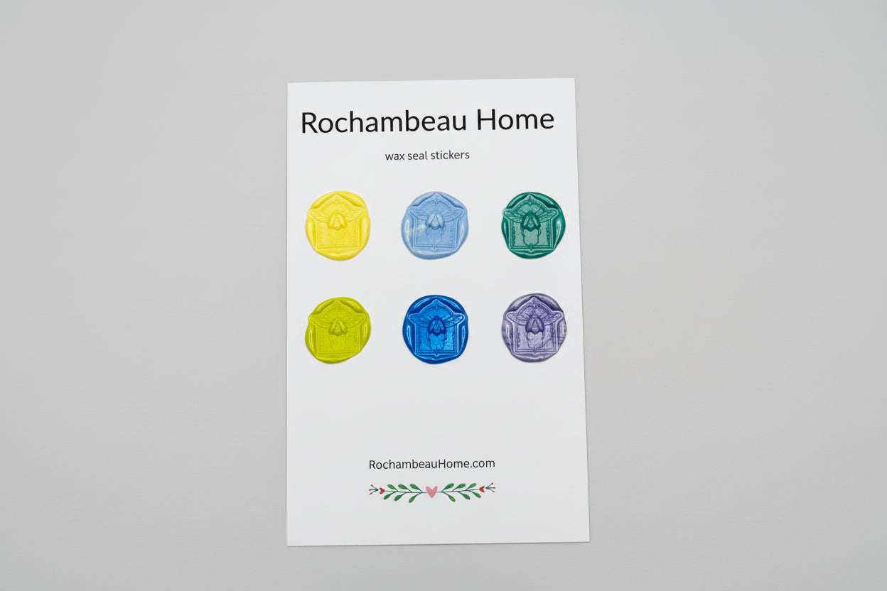 Handmade scarab beetle wax seal stickers created by Rochambeau Home in rich colors, displayed on a backing card