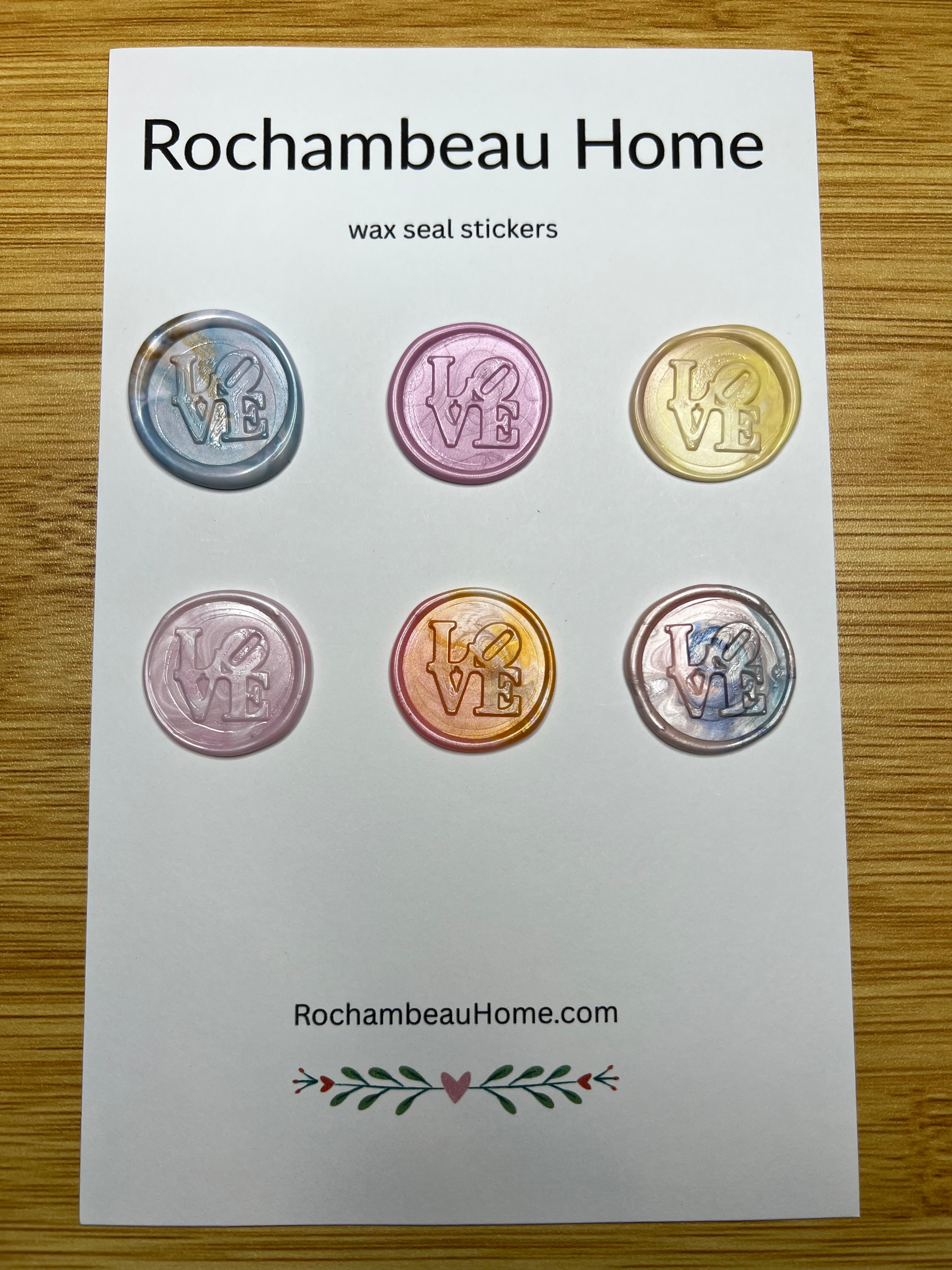 Multicolor wax seals featuring the iconic LOVE lettering on a product card