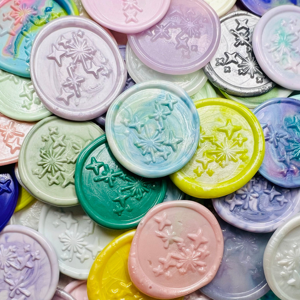 A close up view of Written in the Stars wax seal stickers from Rochambeau Home in various colors of wax