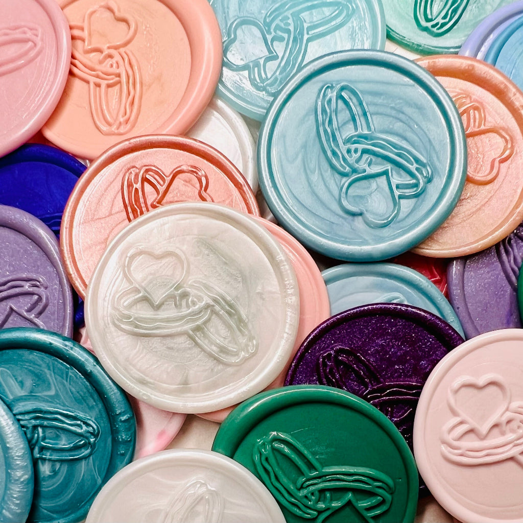 Close up view of Bound in Love wax seal stickers in various colors