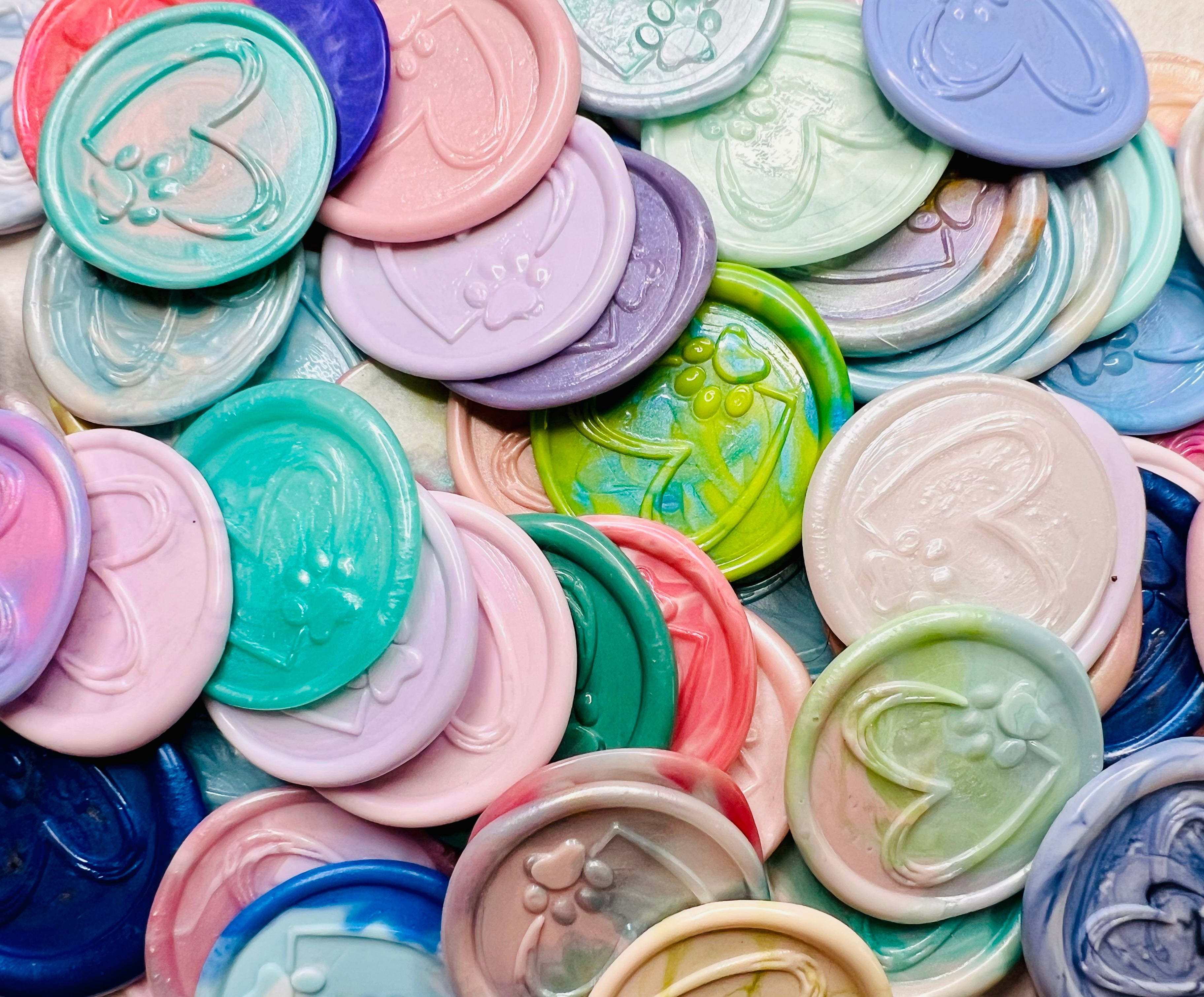 Various Paw & Heart wax seal stickers in a pile showcasing the embossed details