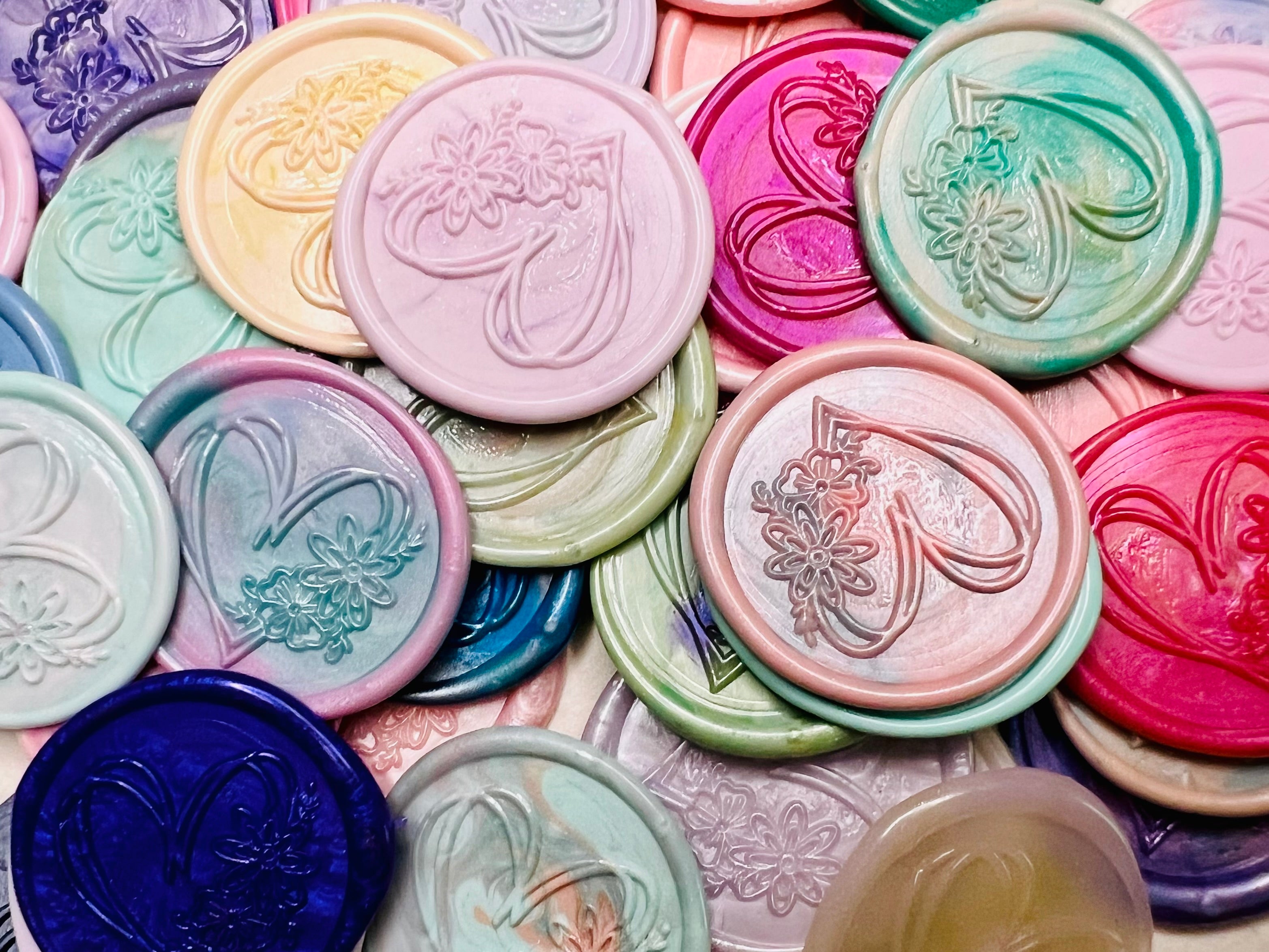 Hand drawn heart with floral accents embossed on a wax seal sticker in various colors