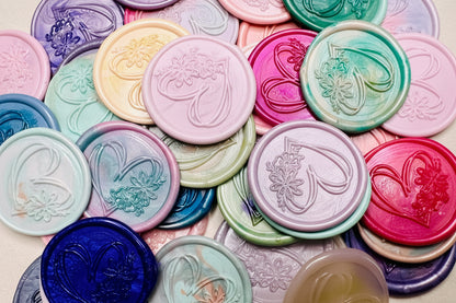 Hand drawn heart with floral accents embossed on a wax seal sticker in various colors