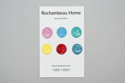 “Hand Made” wax seal stickers created by Rochambeau Home with 3D embossed handprint in a solid multicolor theme