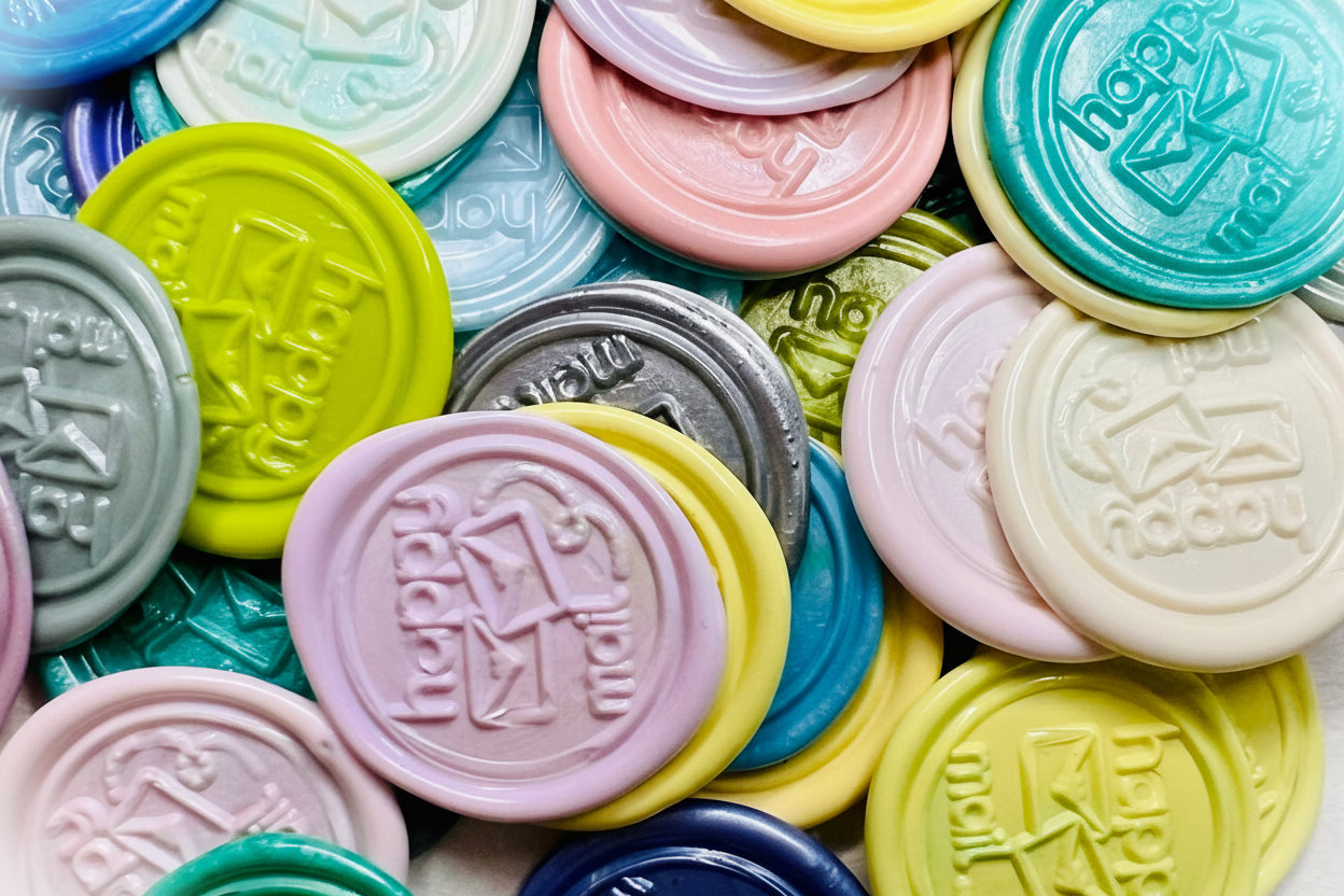 Colorful 'Happy Mail' wax seal stickers created by Rochambeau Home in various colors.