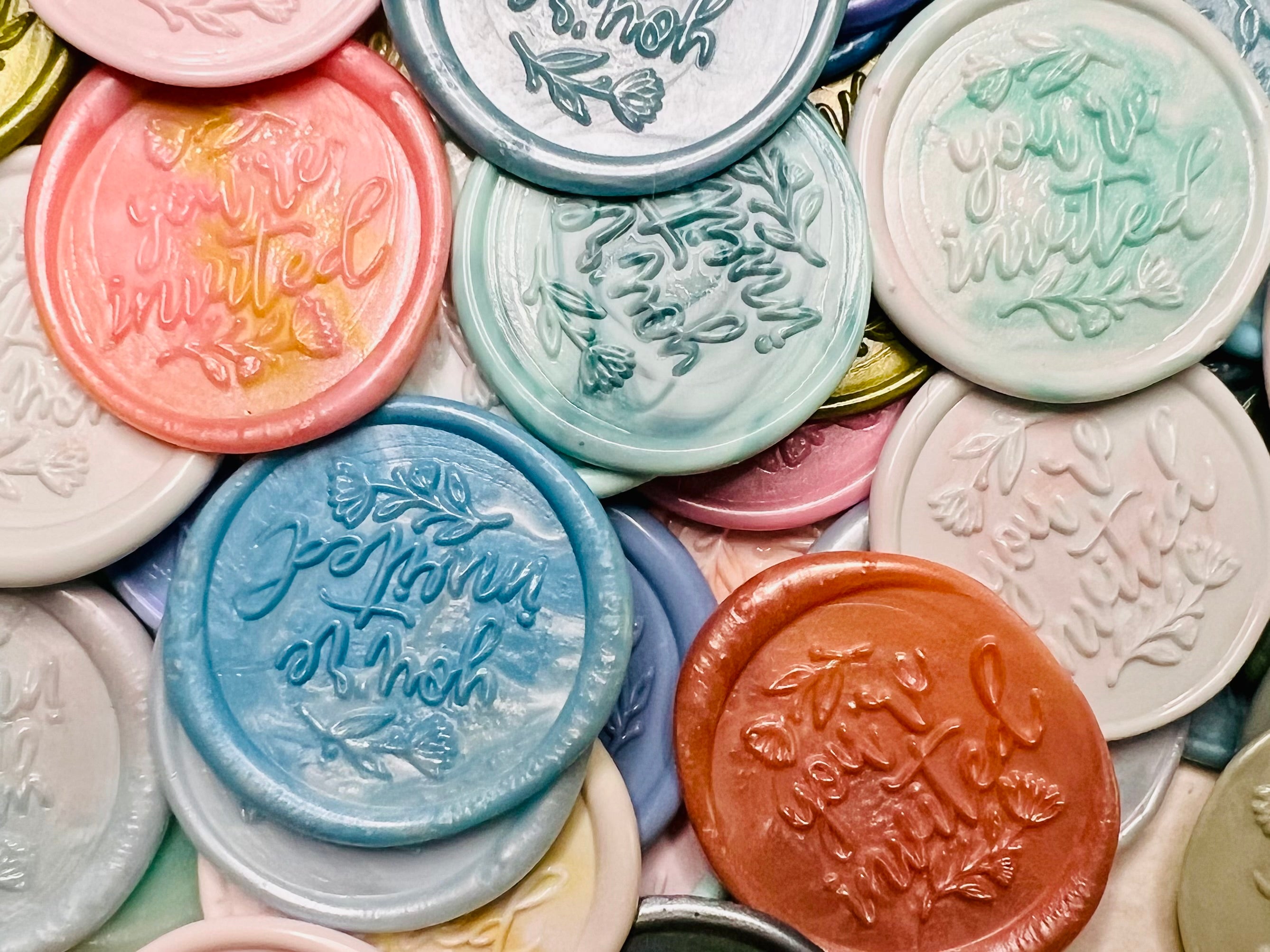 Close up view of the Handcrafted “You’re Invited” wax seal stickers in various colors