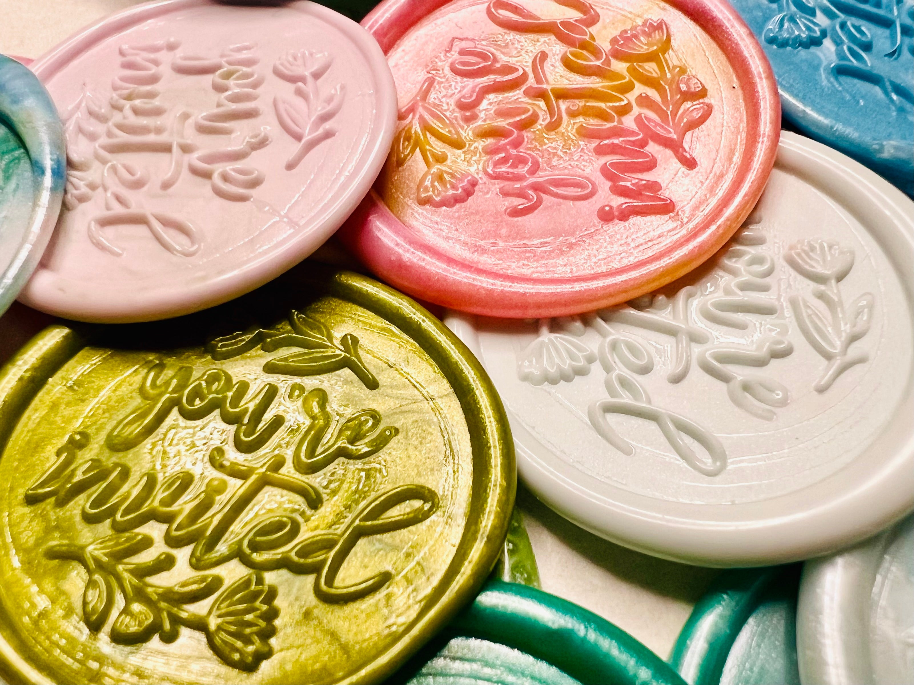 Close up view of the Handcrafted “You’re Invited” wax seal stickers showcasing the floral detail