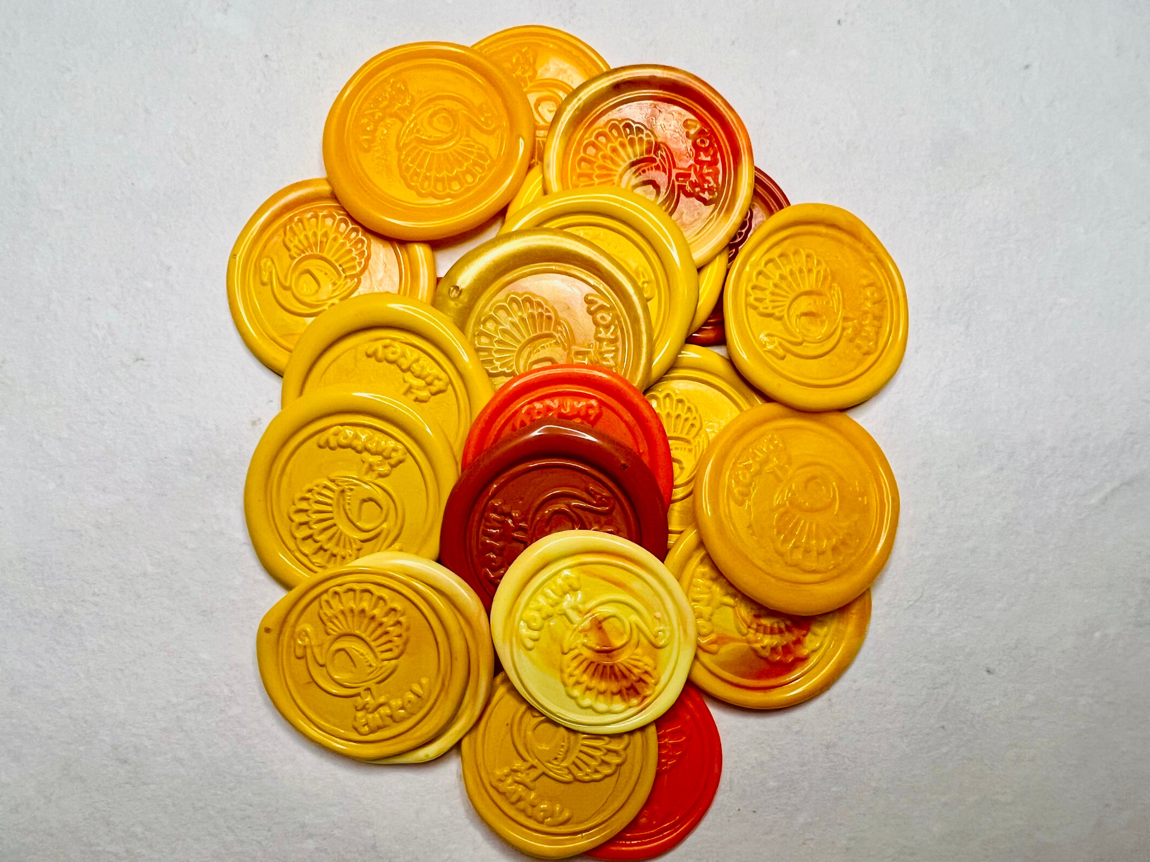 Stack of yellow and orange Gobble & Glow wax seal stickers on natural handmade paper